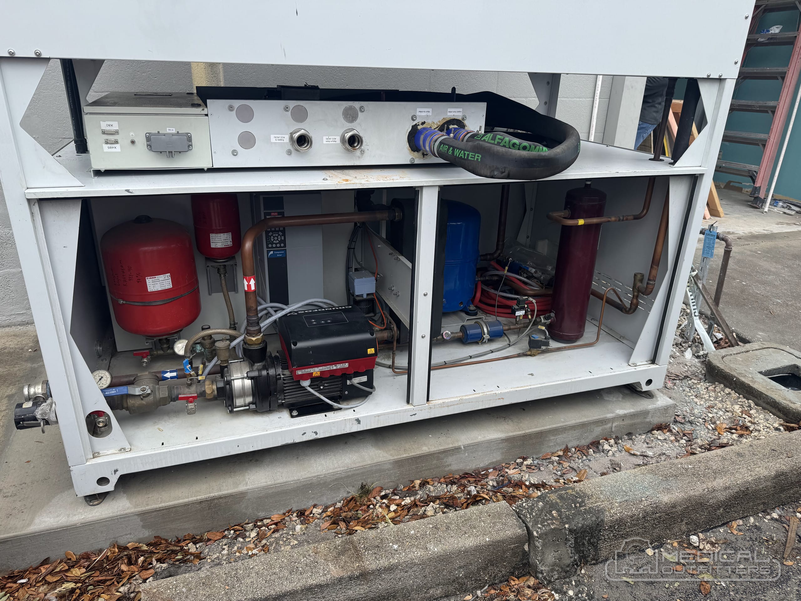 Inside an MRI chiller: pumps, compressor and expansion tank inspected on a Medical Outfitters installation