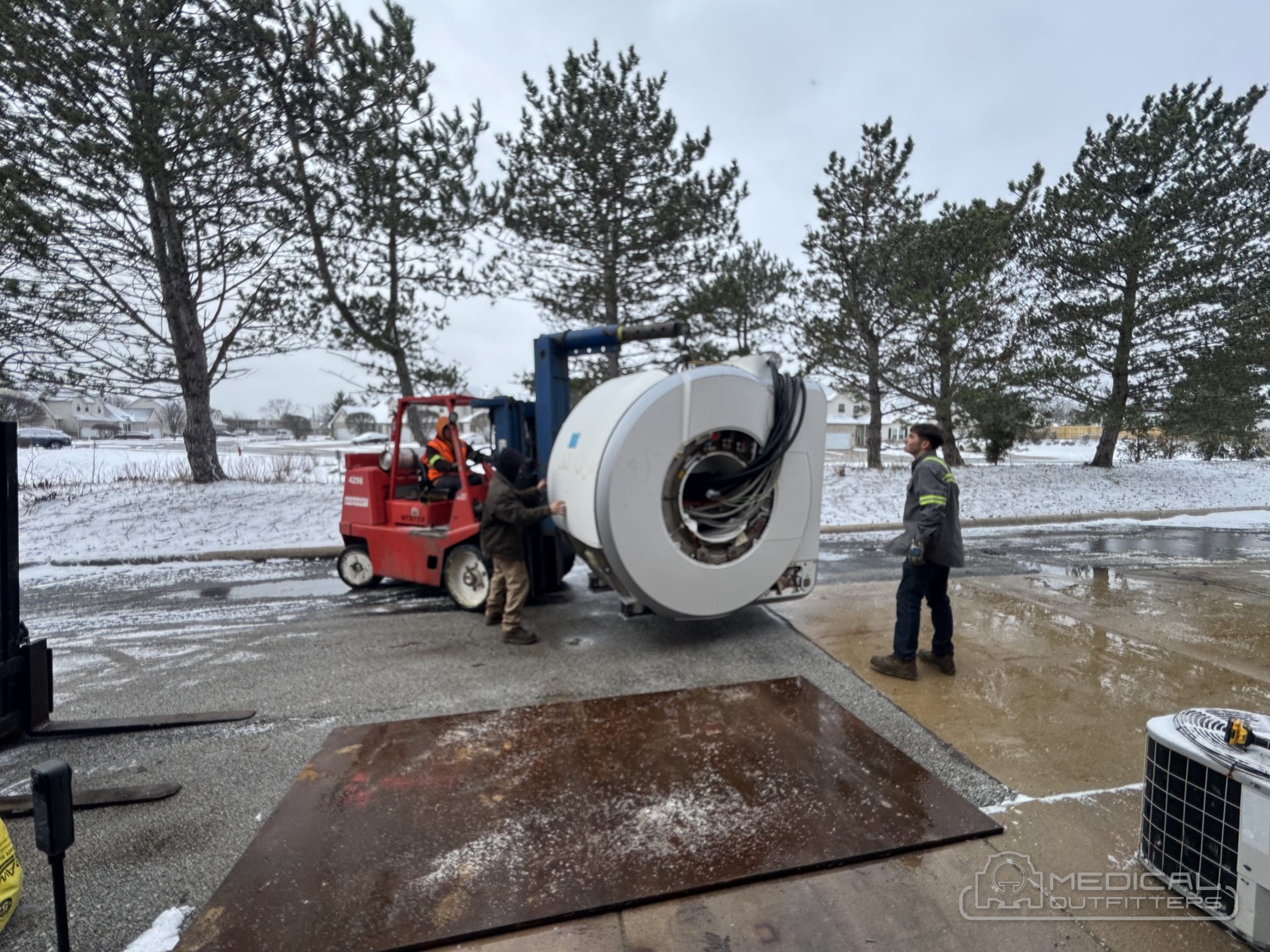 Medical Outfitters rigging crew moving an MRI magnet on a telehandler during a winter delivery
