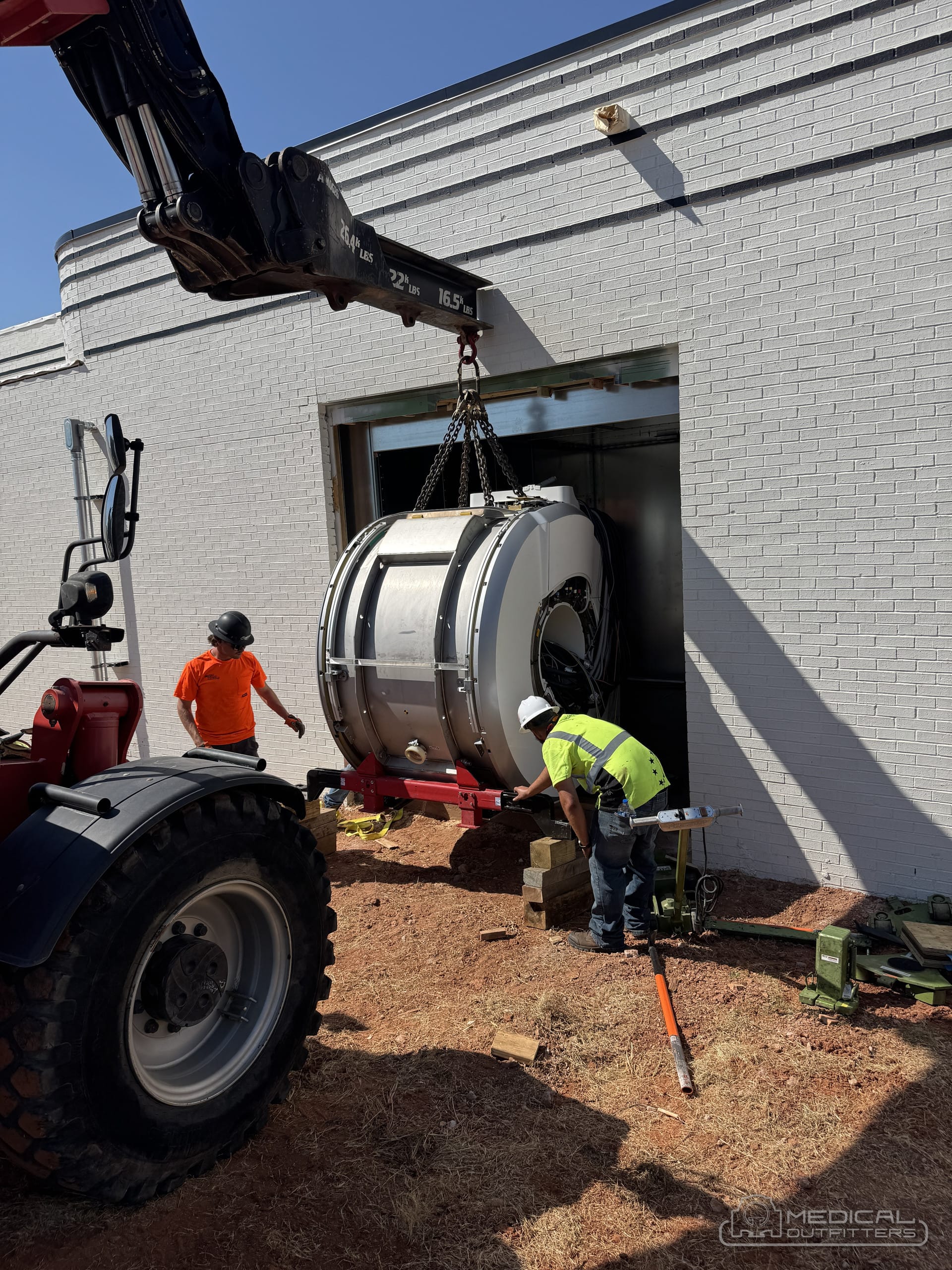 Medical Outfitters crew guiding an MRI magnet through the magnet room opening
