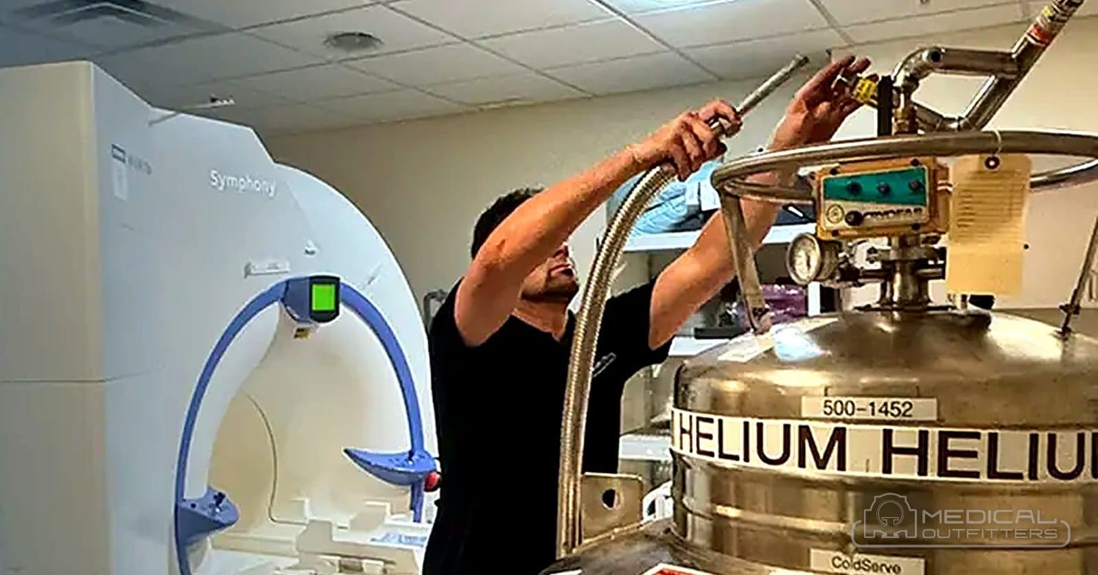 Medical Outfitters engineer performing an MRI helium fill with a cryogenic helium dewar beside the magnet