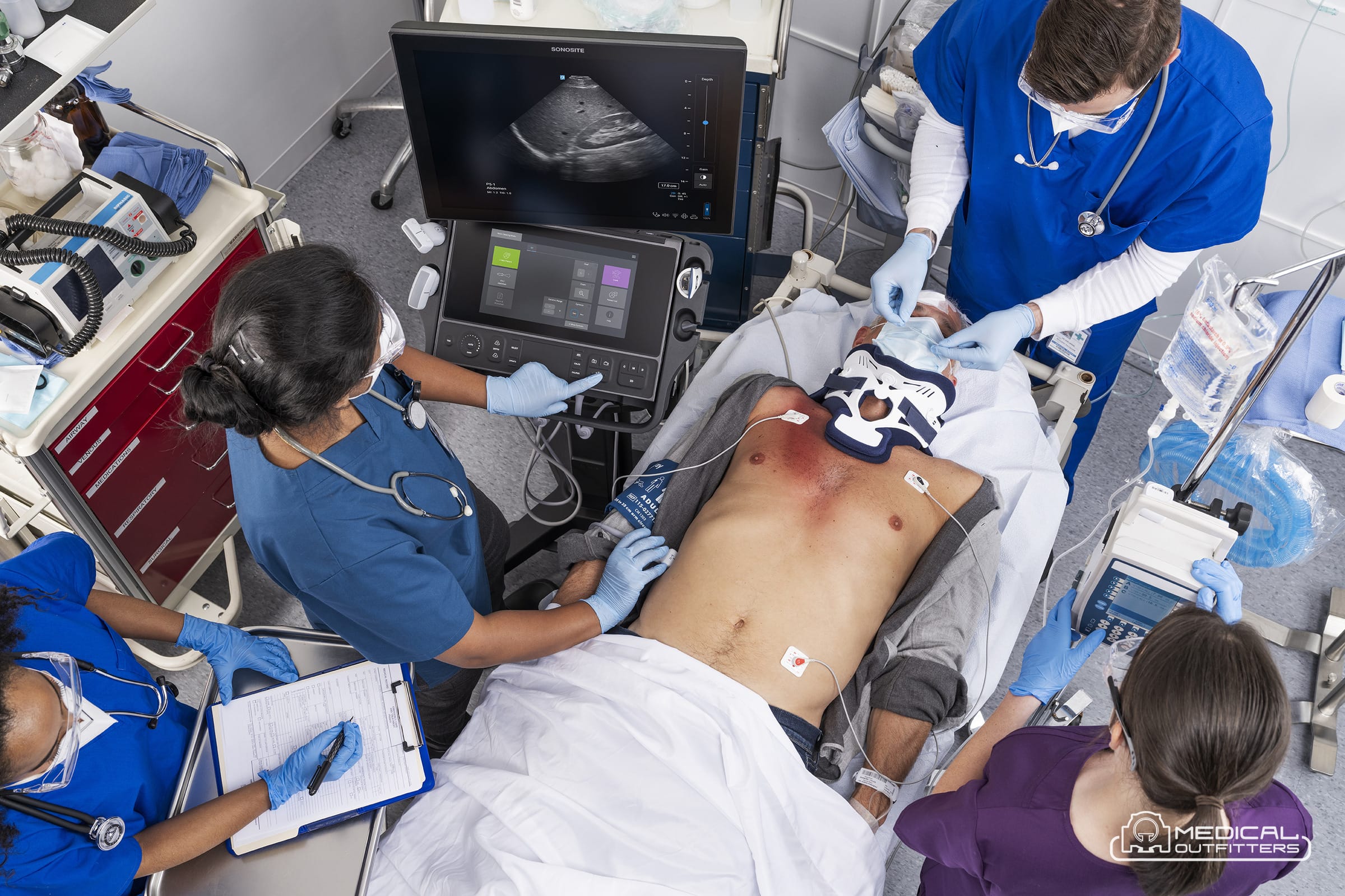Emergency team performing a FAST exam with a Fujifilm Sonosite LX ultrasound system in a trauma bay, photo courtesy of Fujifilm Sonosite, with the Medical Outfitters watermark